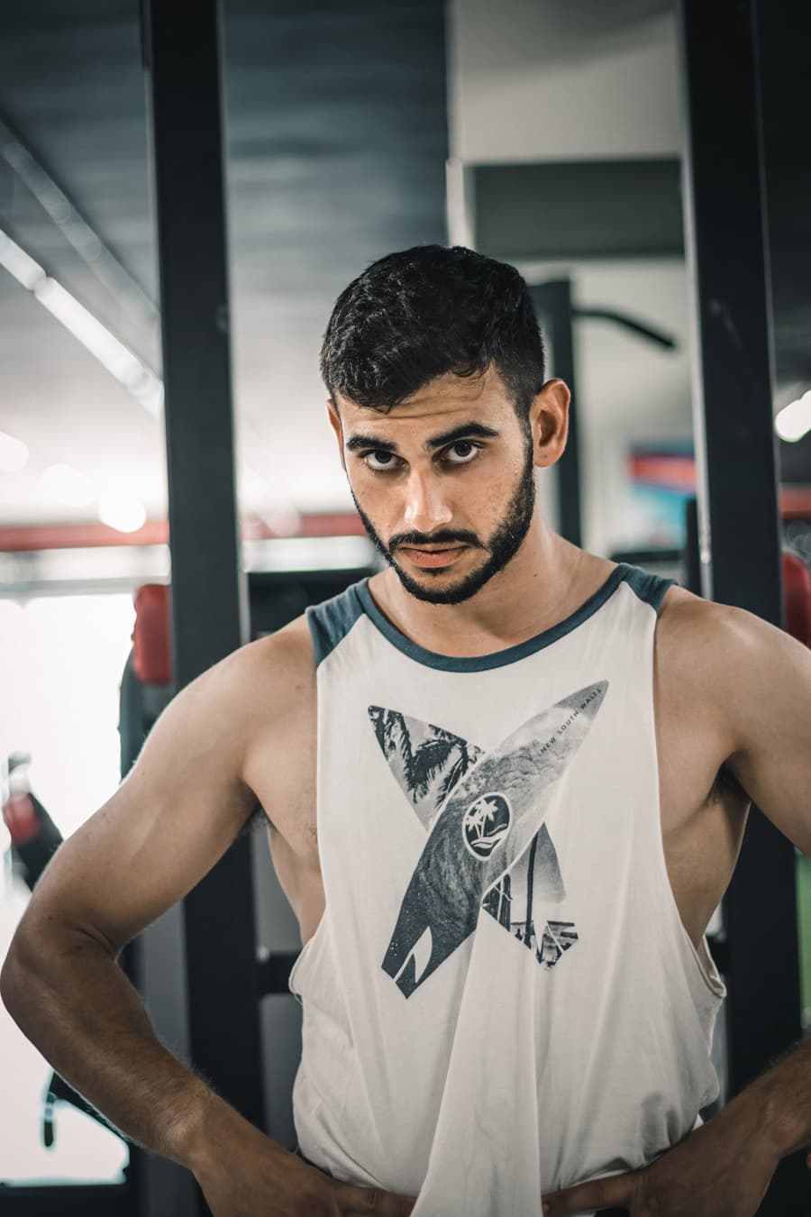 Full-body standing gym photo with relaxed arms at the sides